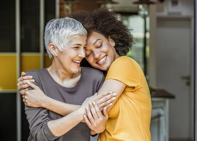 Happy patients are hugging after getting dental treatment.